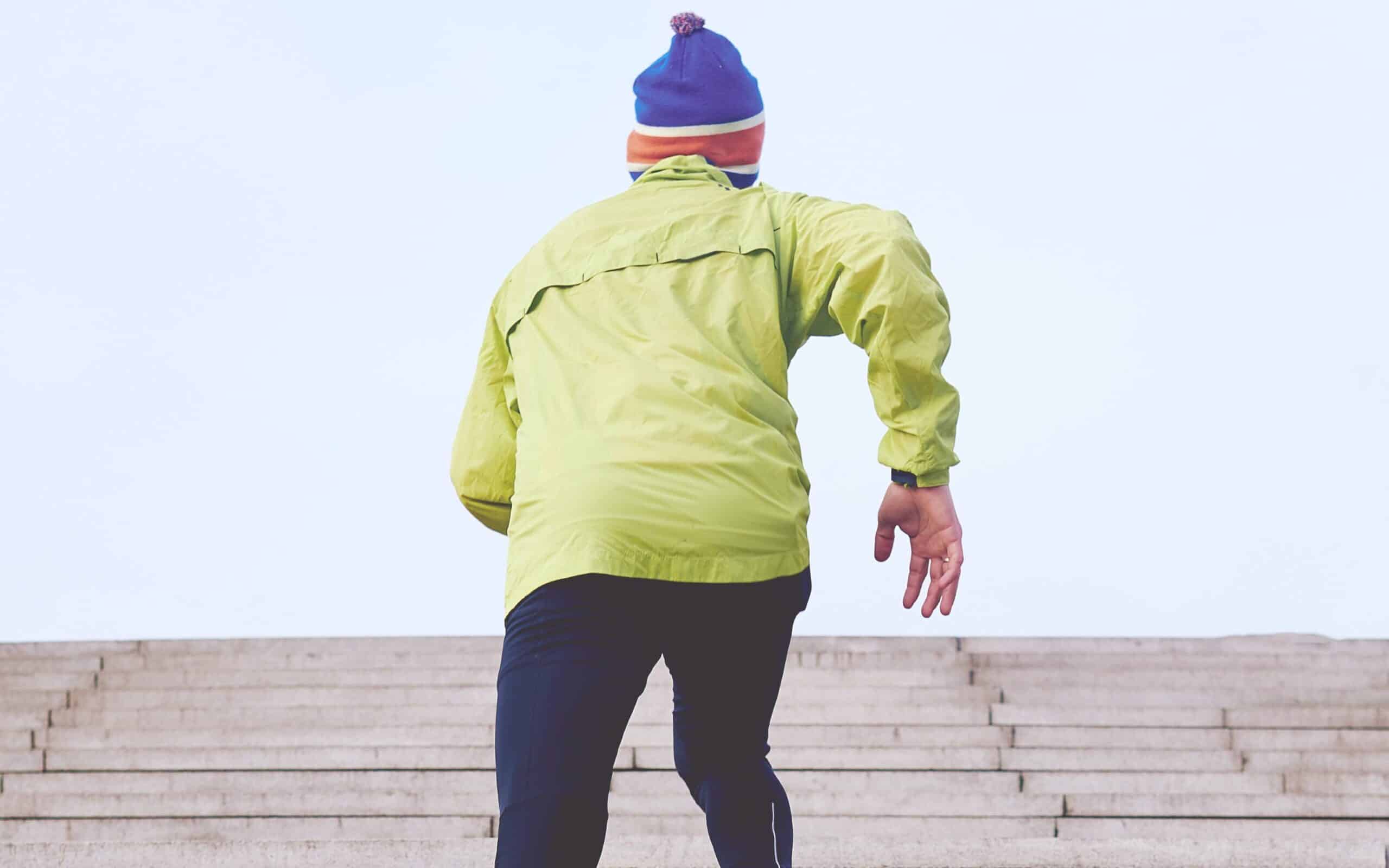 A male runner doing uphill intervals to improve running posture.
