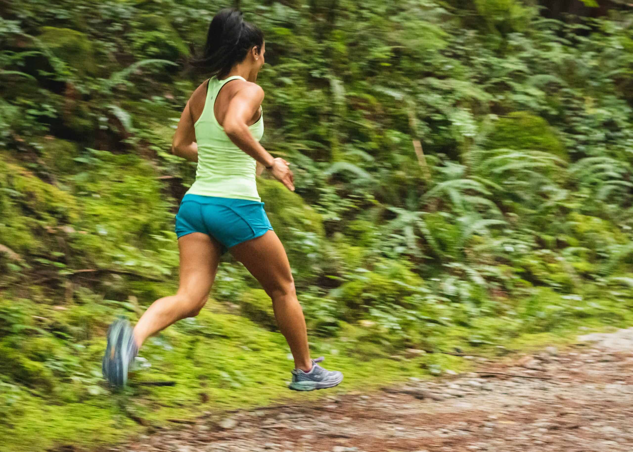 Woman running on a dirt trail. The secret to a good running pace is long slow runs.