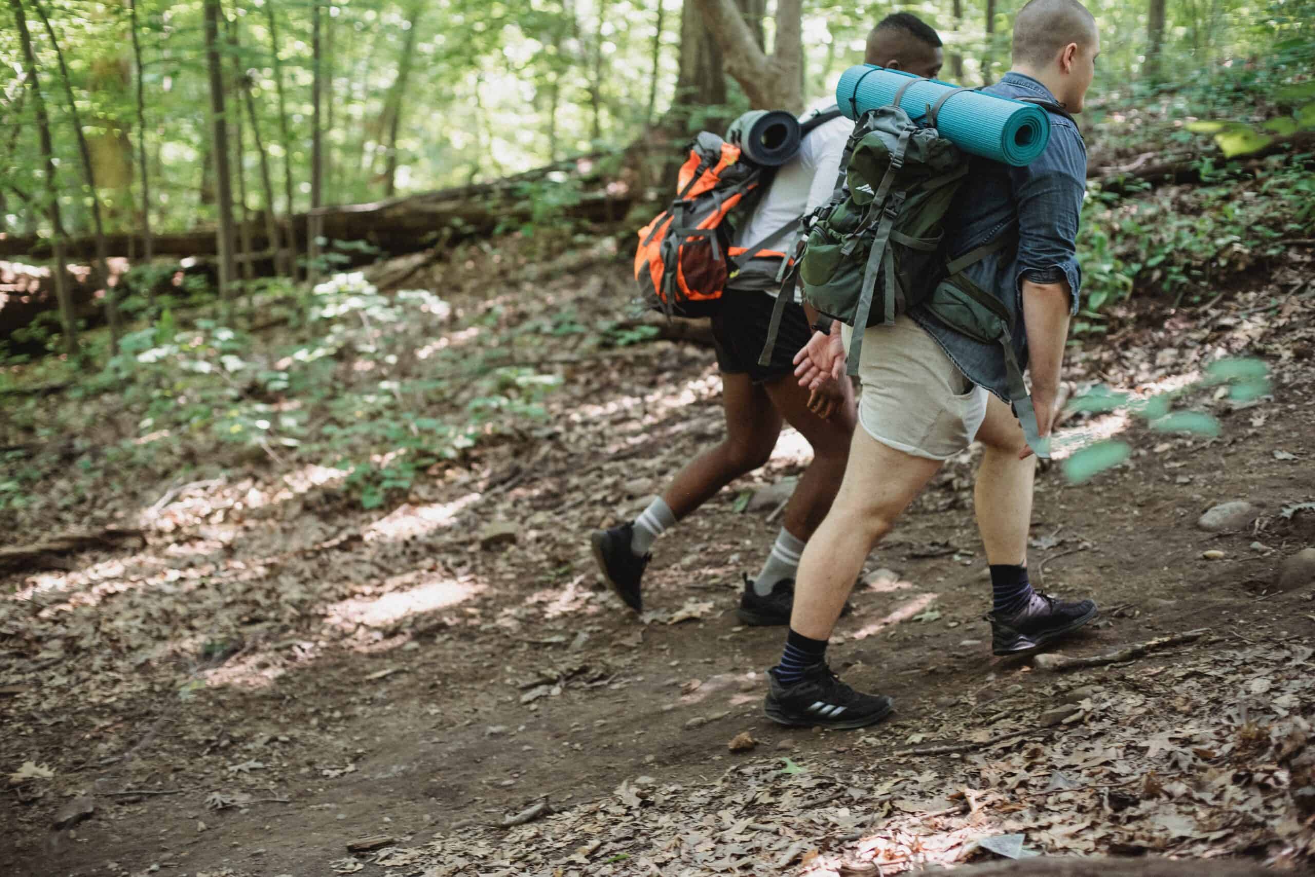 Two walkers training while rucking for a marathon in the woods.