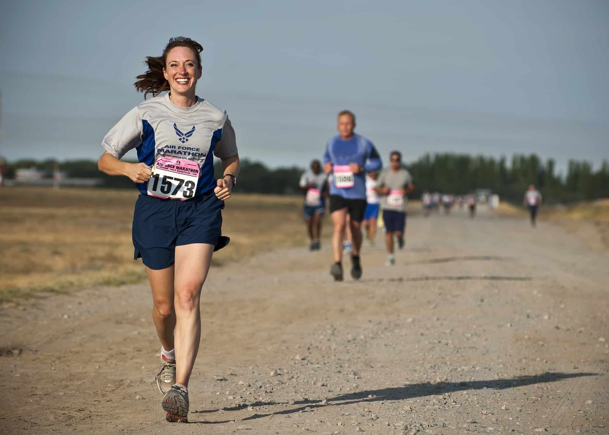 A women running the Air Force Marathon and smiling due to runner's high.