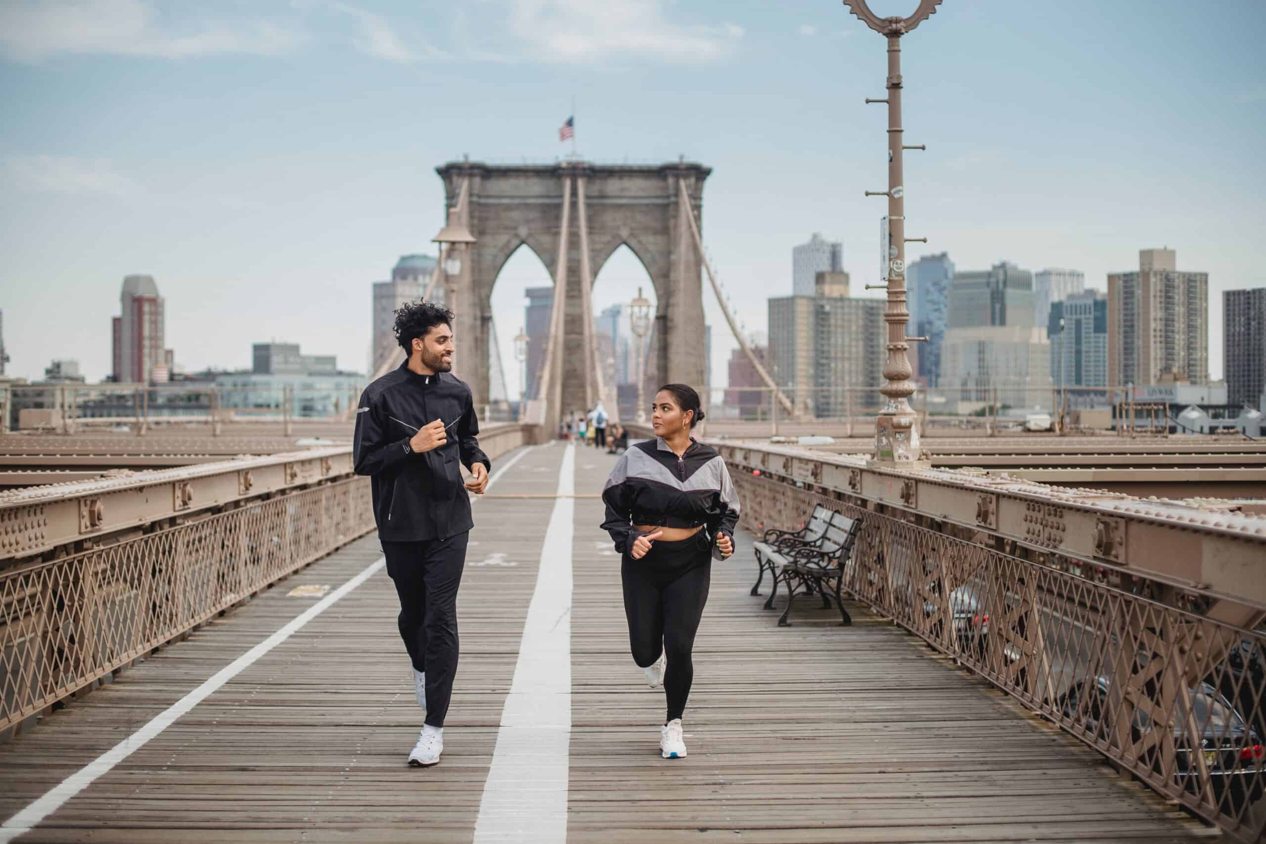 Two runners on the Brooklyn Bridge participating in Zone 2 running over long distances.