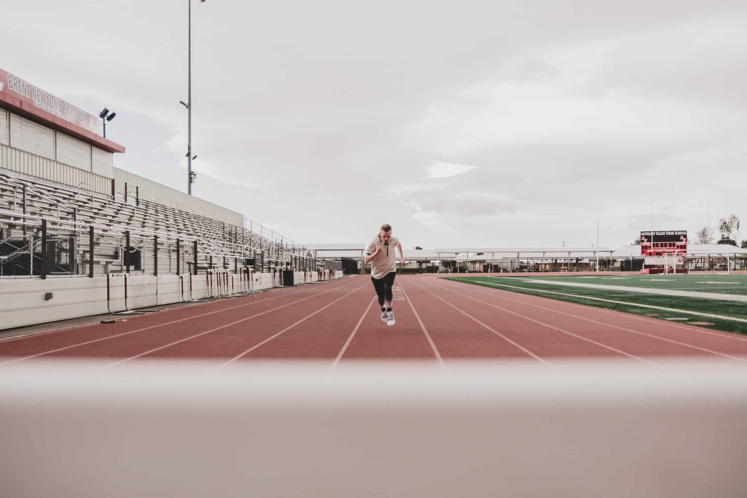 A man running on a track doing polarized training workouts. 