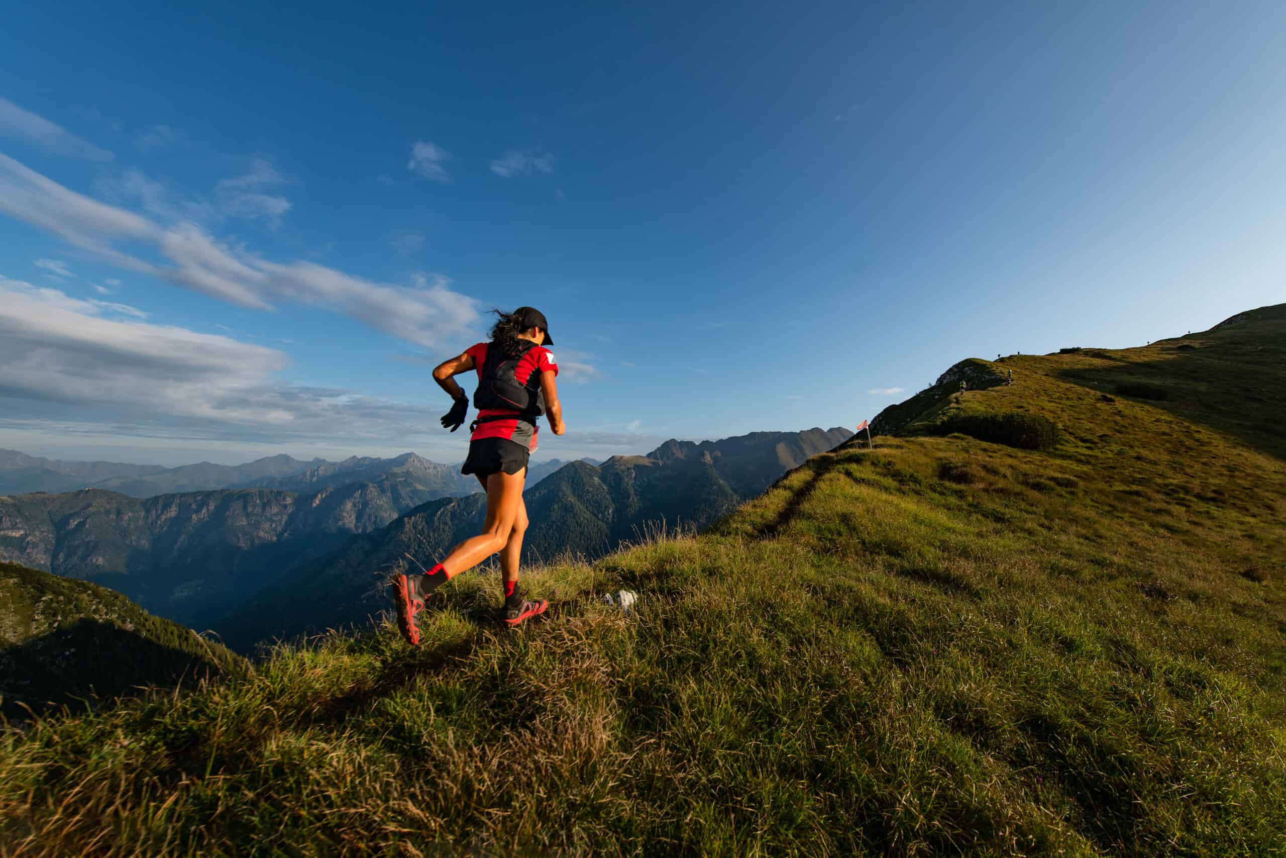 Sporty mountain woman rides in trail during endurance trail when learning how to start trail running.