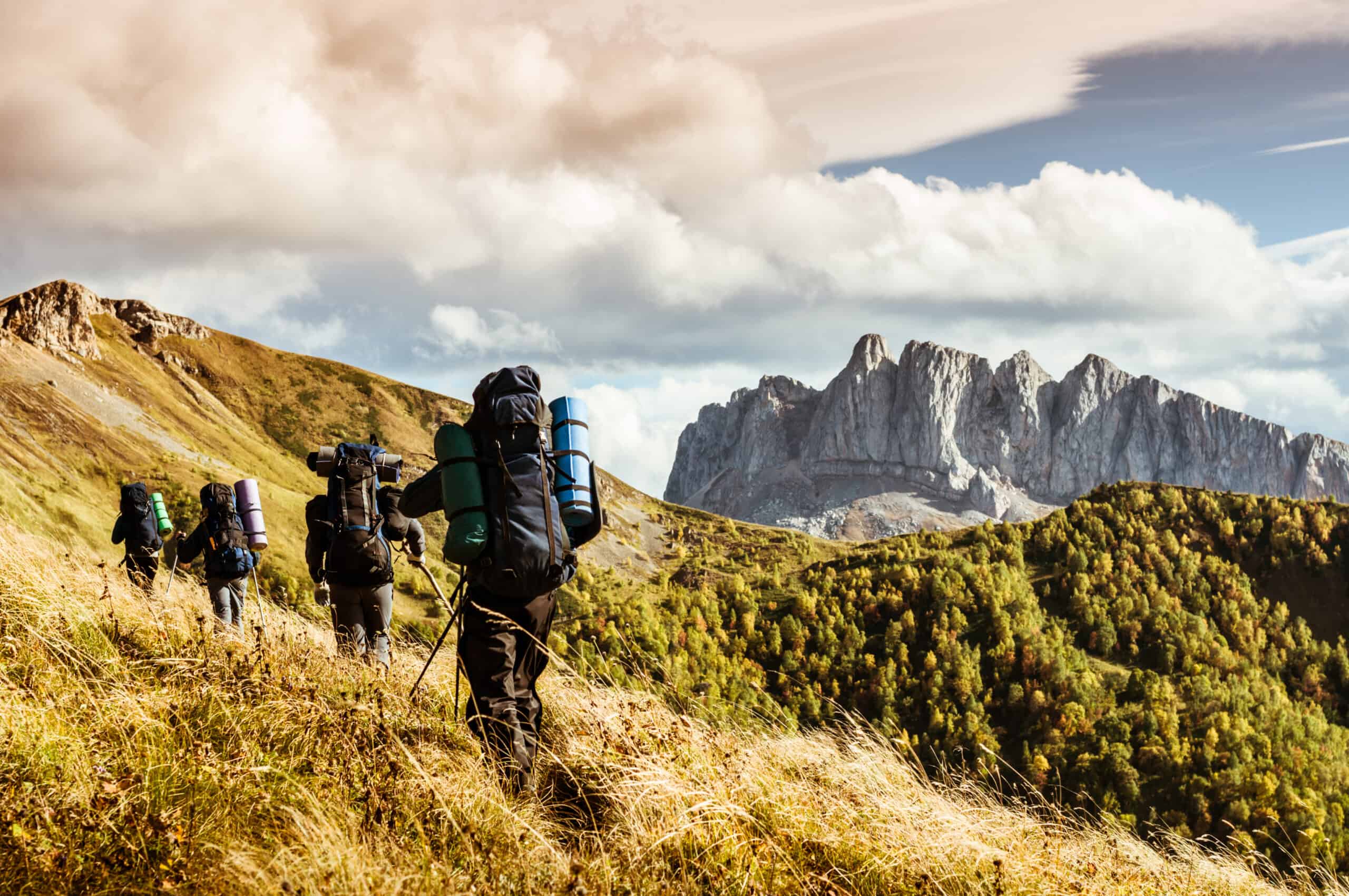 Four hikers hiking in the mountain during autumn on a rucking.