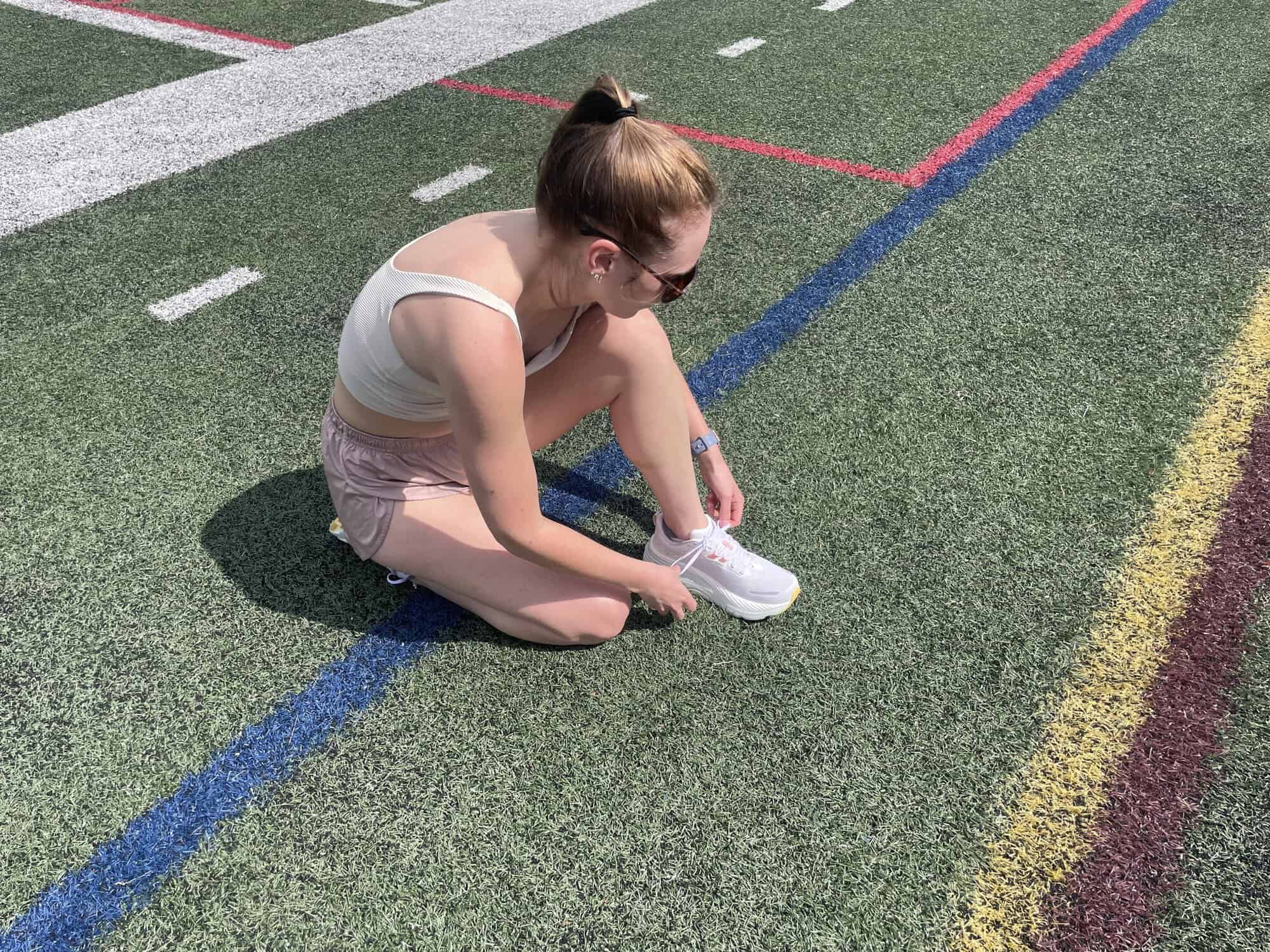 Writer Gabi Horndorp tying the Saucony Hurricane 24 on astroturf before a test run.