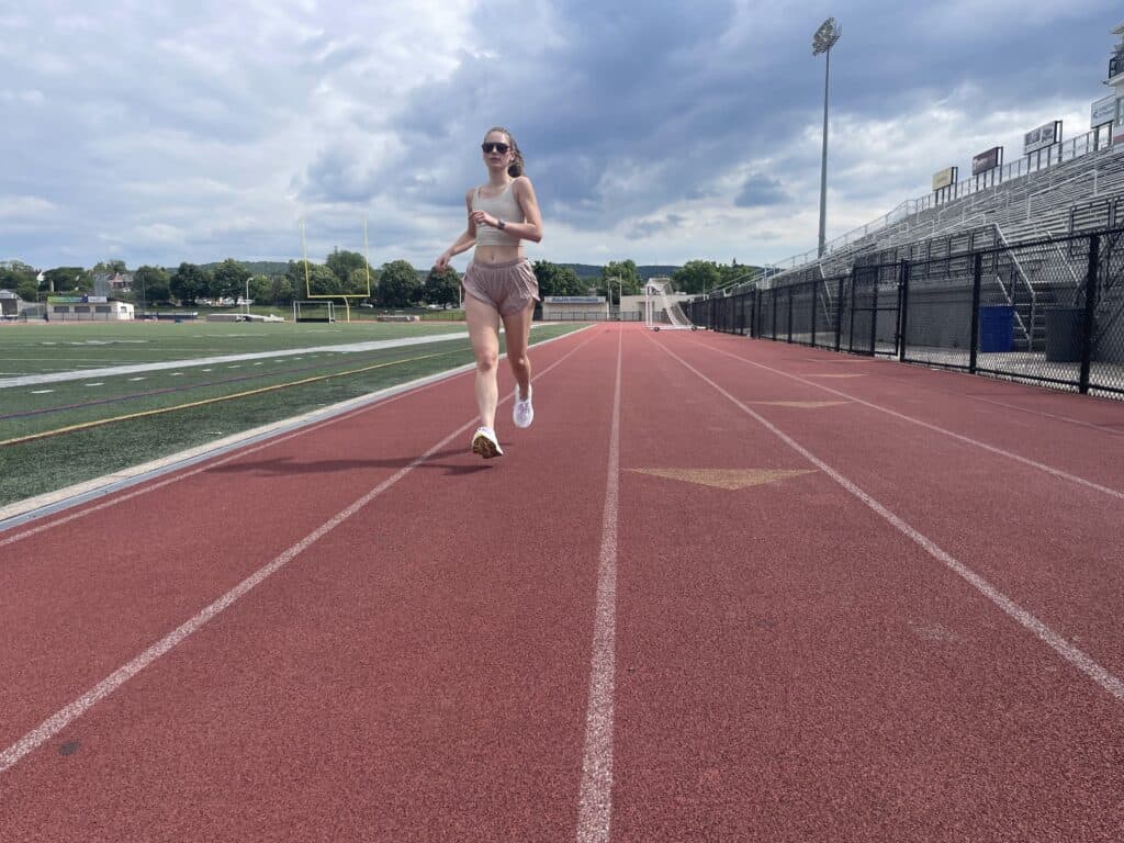 Writer Gabi Horndorp testing the Saucony Hurricane 24 on a high school track, running toward the camera