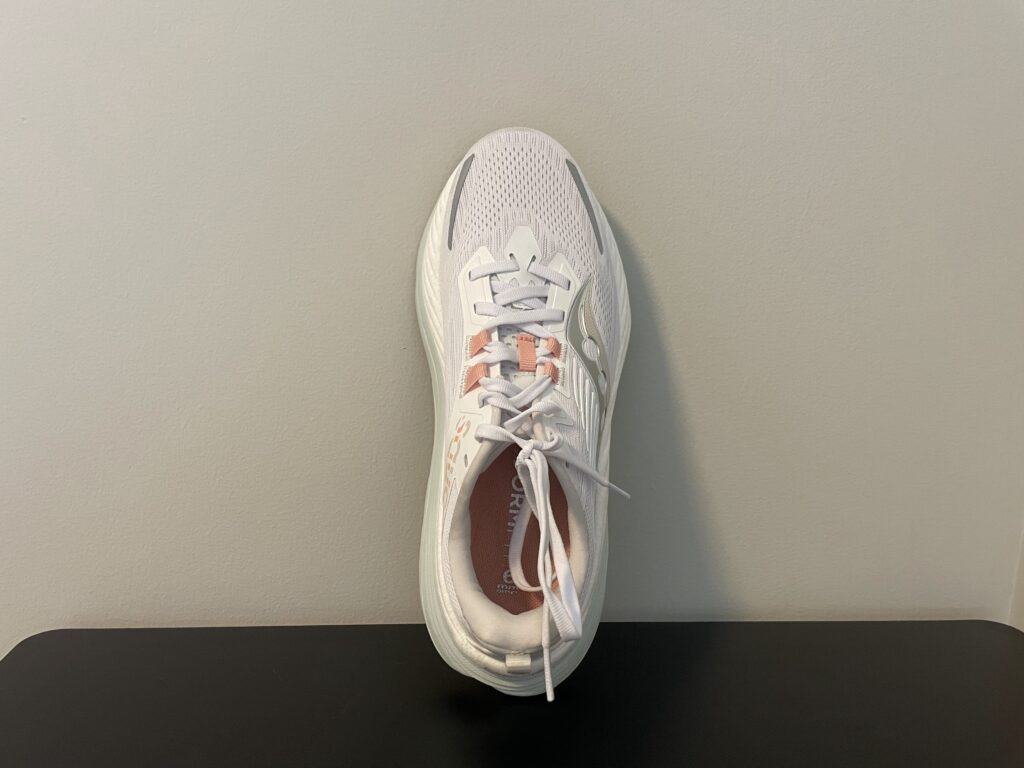 The Saucony Hurricane 24 leaning vertically against a wall, showing a top-down view of the running shoe